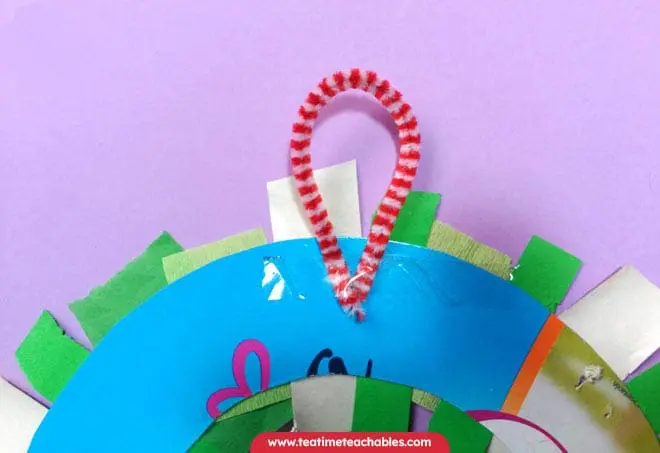Attaching the hanger on the Christmas wreath craft for preschoolers